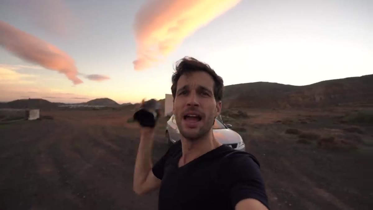 Photographer holding up single 24mm lens to camera in field