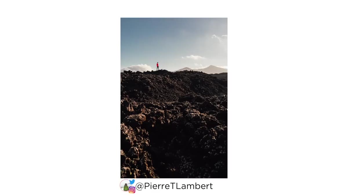 Extreme low angle shot showing volcanic landscape layers receding into distance
