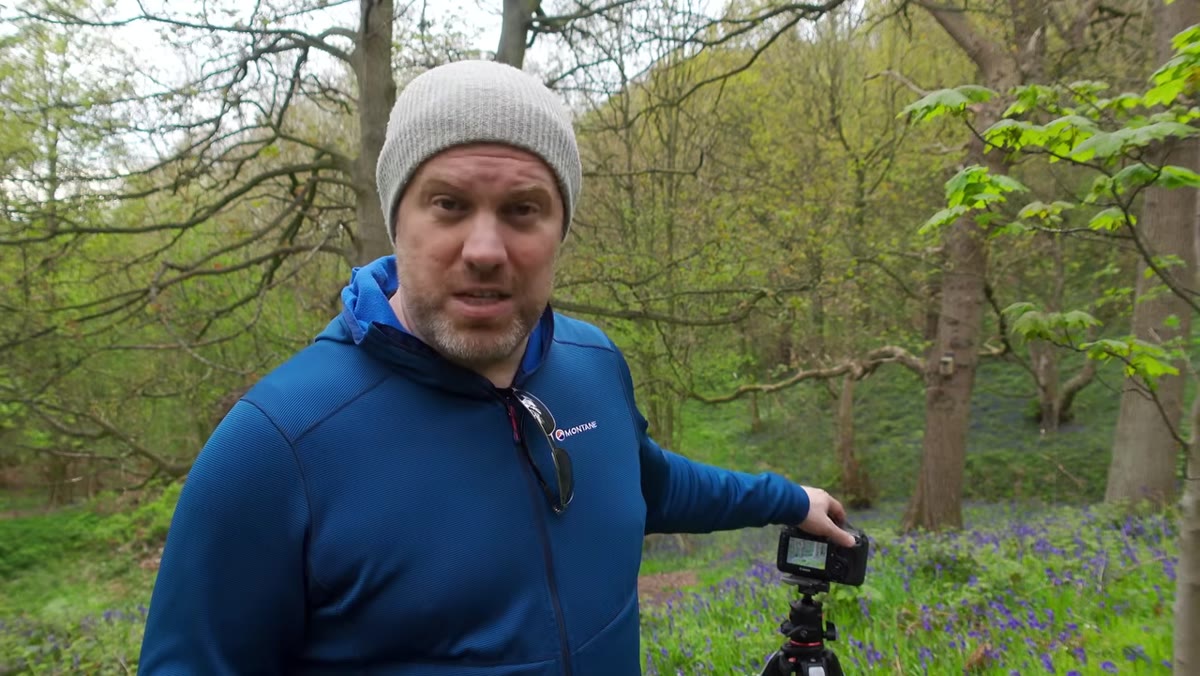 Adam adjusting camera settings on Canon 5D in the field