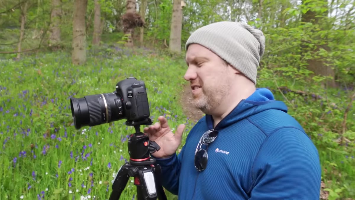 Camera positioned low among bluebells, Adam demonstrating f/16 setting
