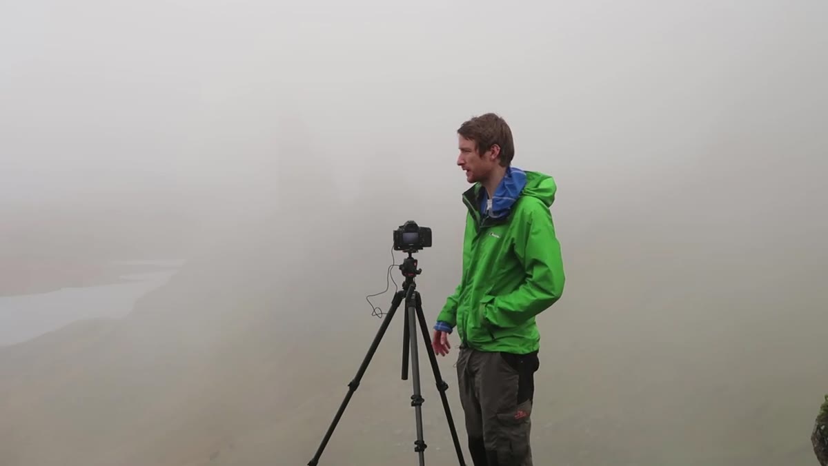 Heaton looking around Old Man of Storr evaluating composition options in fog