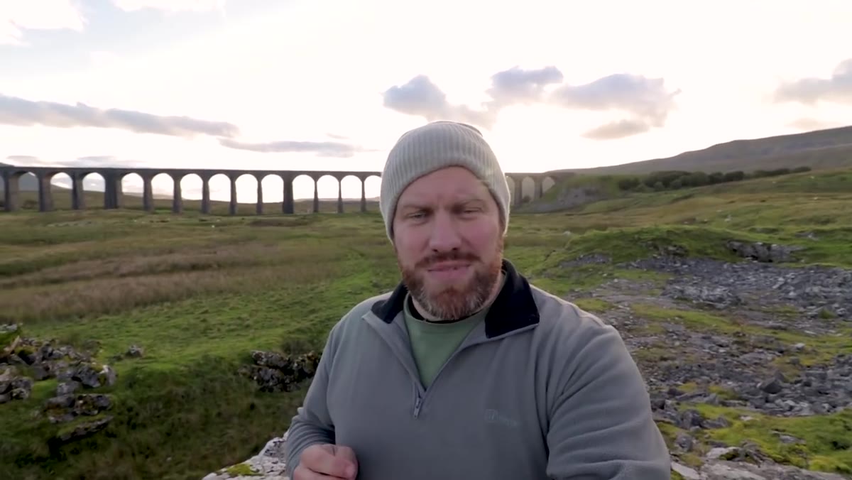 Camera positioned low on limestone ledge toward viaduct