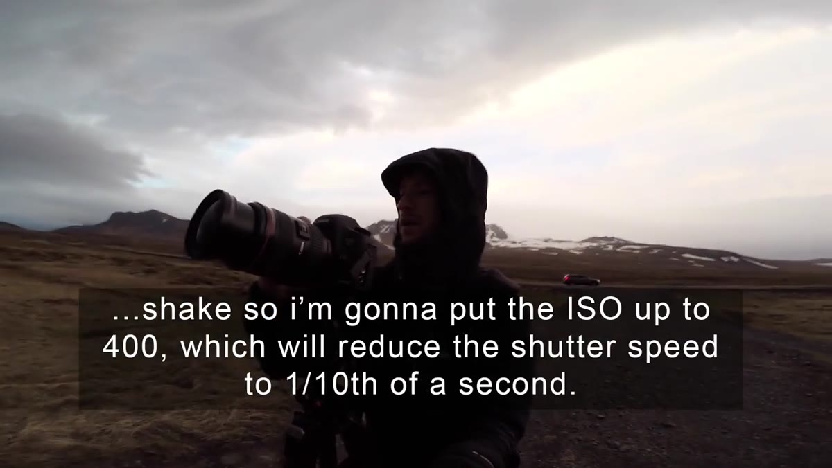 Camera on tripod with storm clouds visible behind the volcanic crater