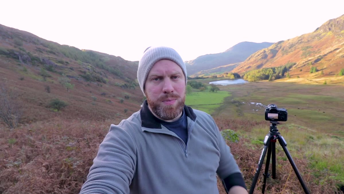 Photographer shooting at 40mm, mountain lit in foreground, shadowed valley behind