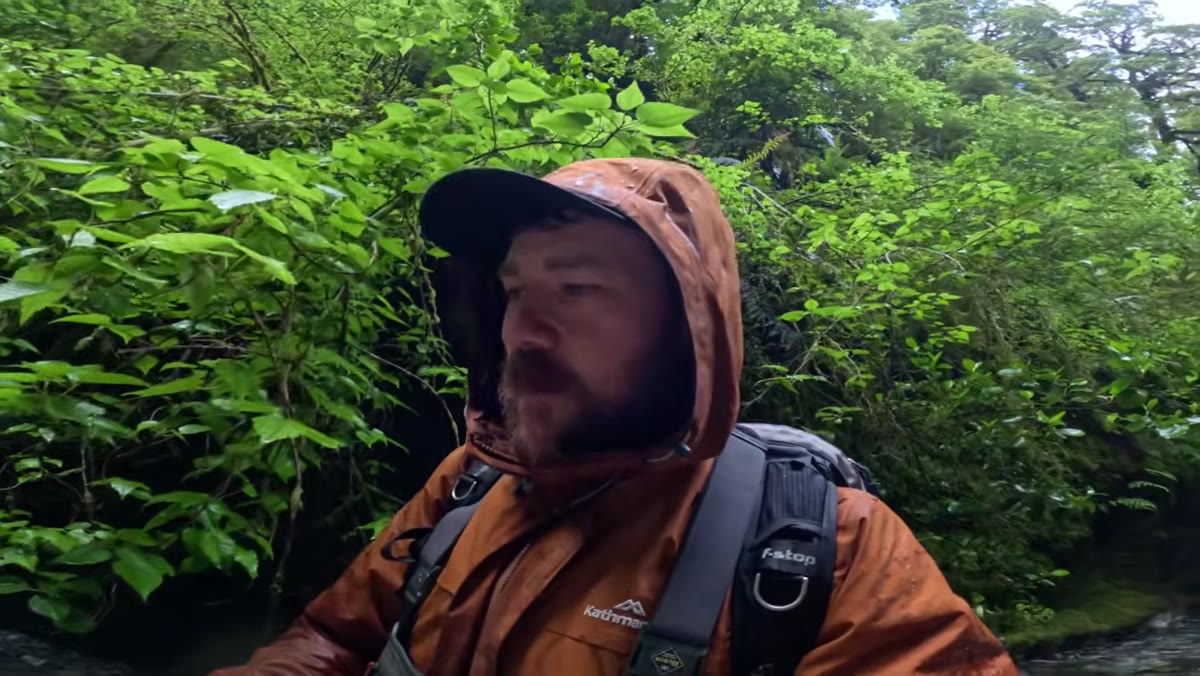 Photographer wading chest-deep to push further into unexplored gorge section
