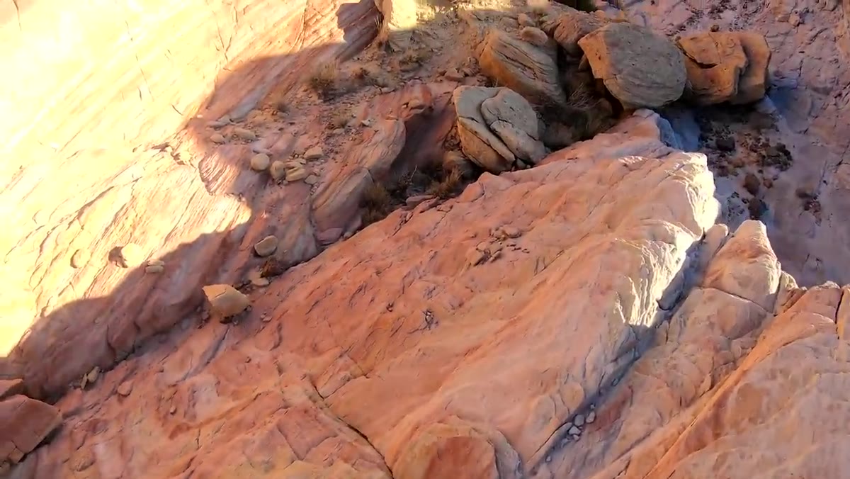 Heaton scrambling across red rocks without camera raised
