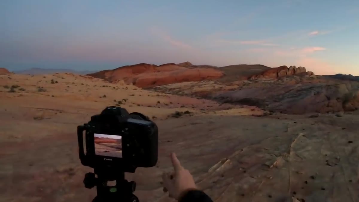 Canyon zigzag lines leading to a red rock peak in fading light