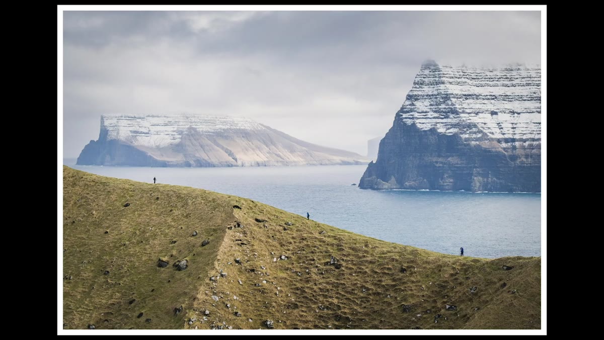 Three hikers spaced along a ridgeline, shot from distance