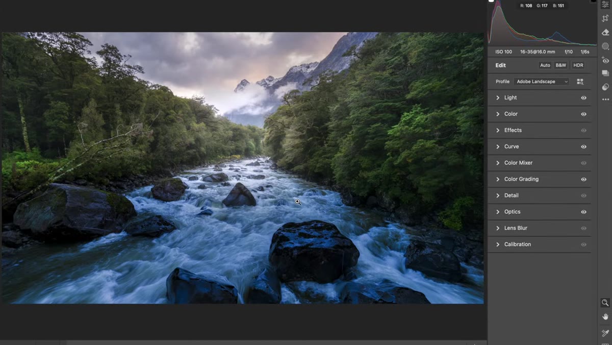 Brush tool active, warming and desaturating shadow regions in river