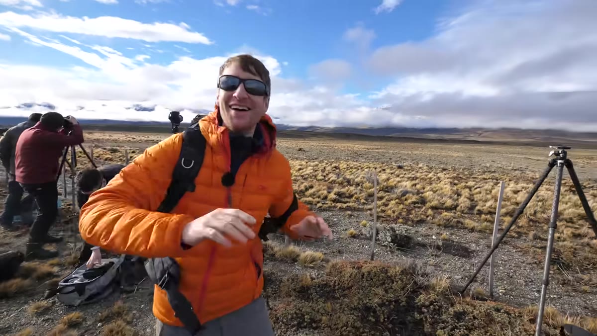 Heaton pointing toward layered cloud and mountain range