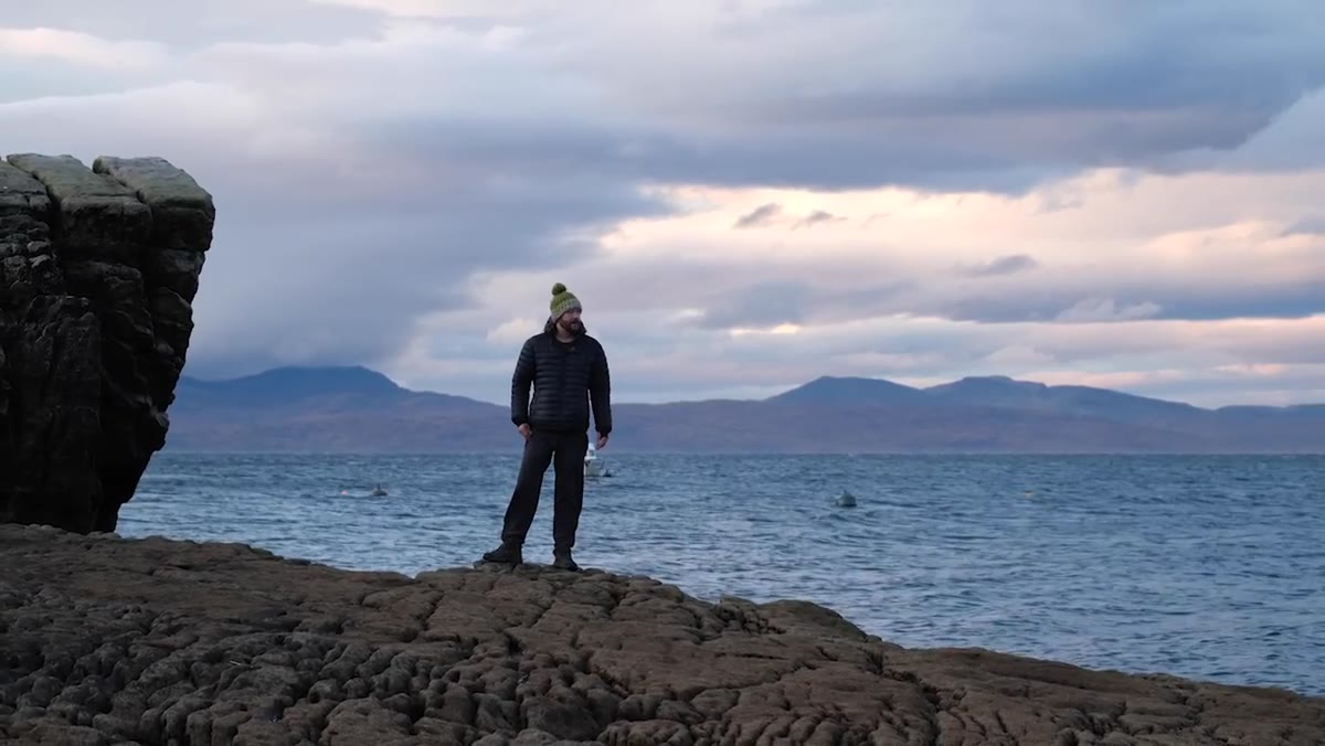 Nigel describing plans to return for sunset, gesturing toward the water
