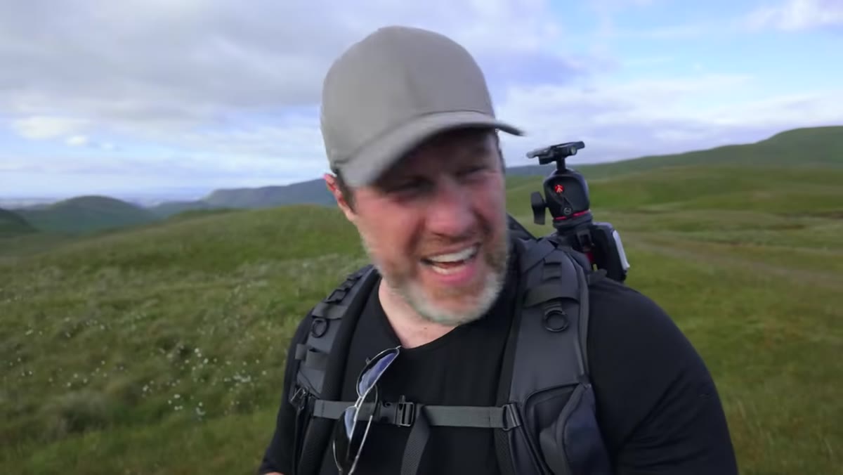 Photographer locating small cotton grass cluster on moorland