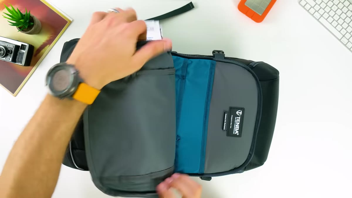 Mark opening the front pocket, showing laptop sleeve and smaller organizer pockets