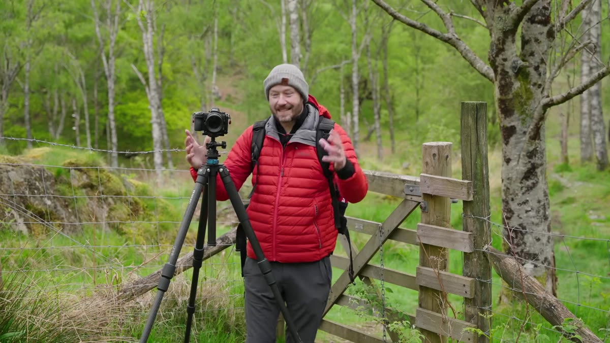 Danson holding camera and 85mm prime lens outdoors