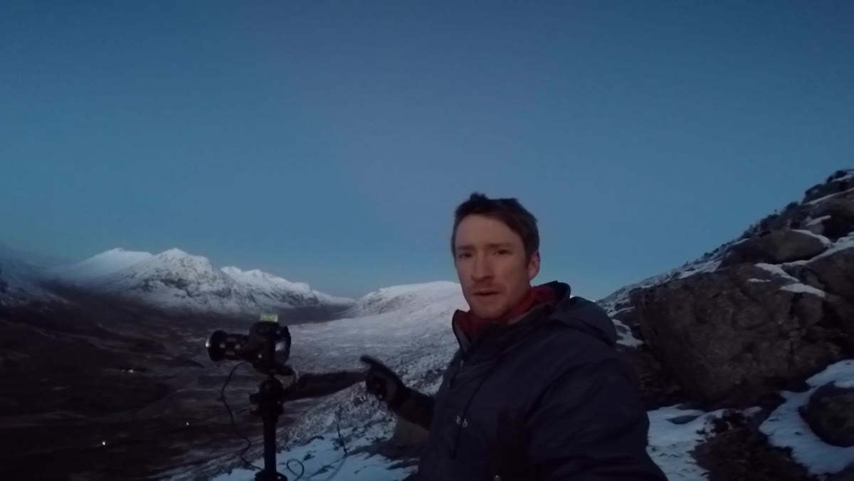 Camera on tripod framing wide panoramic view of Glencoe mountains and road