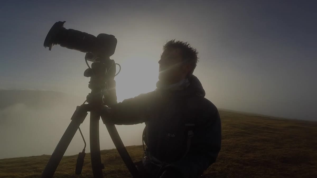 Summit of Blencathra briefly clearing with hikers visible on top