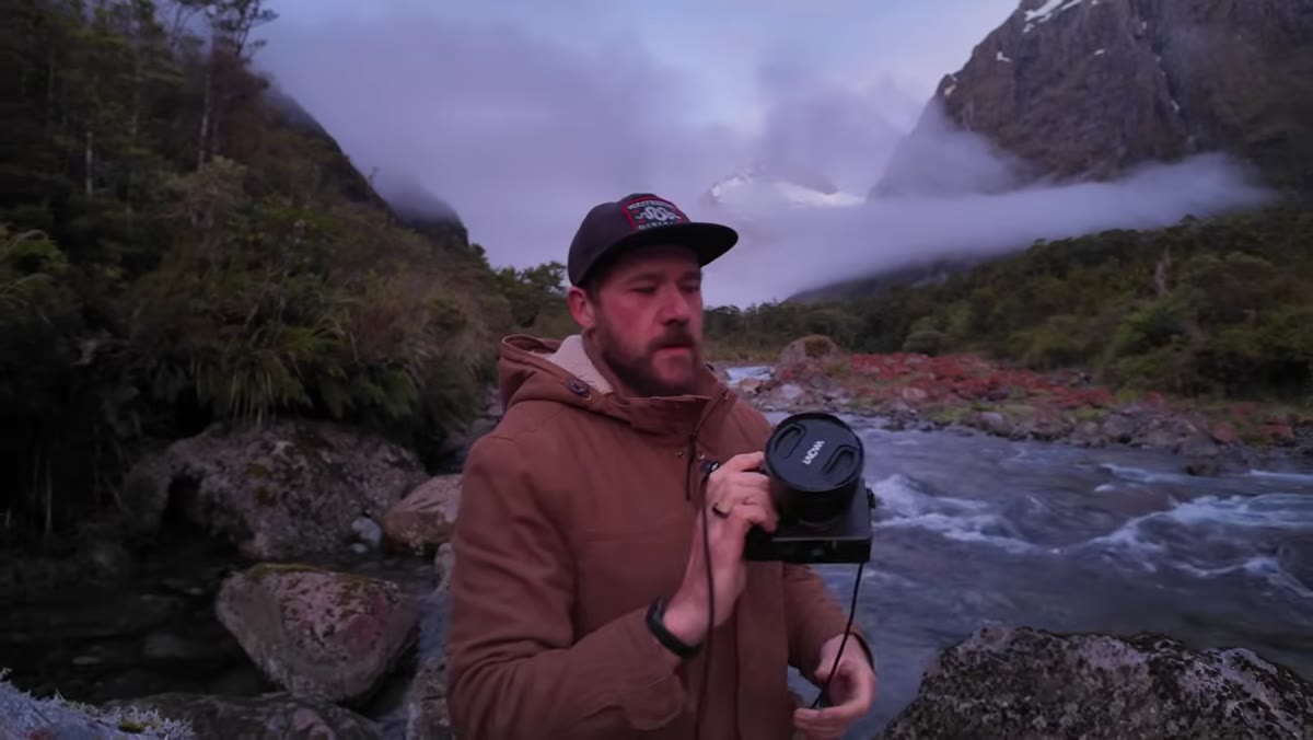 Wide angle prime lens mounted on camera, steep valley walls visible