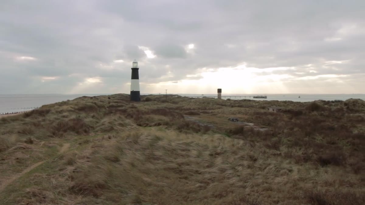 Photographer standing alone at the elevated tip of Spurn Point