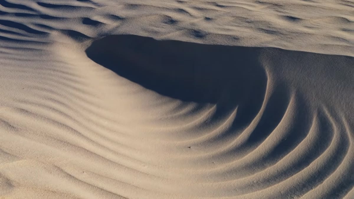 Last light hitting dune textures during final minutes of golden hour