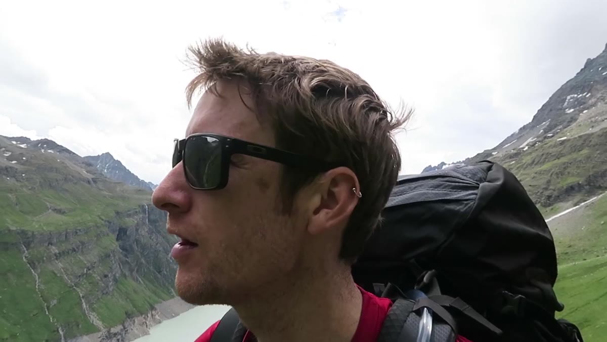 Thomas hiking upward into alpine valley, mountains ahead