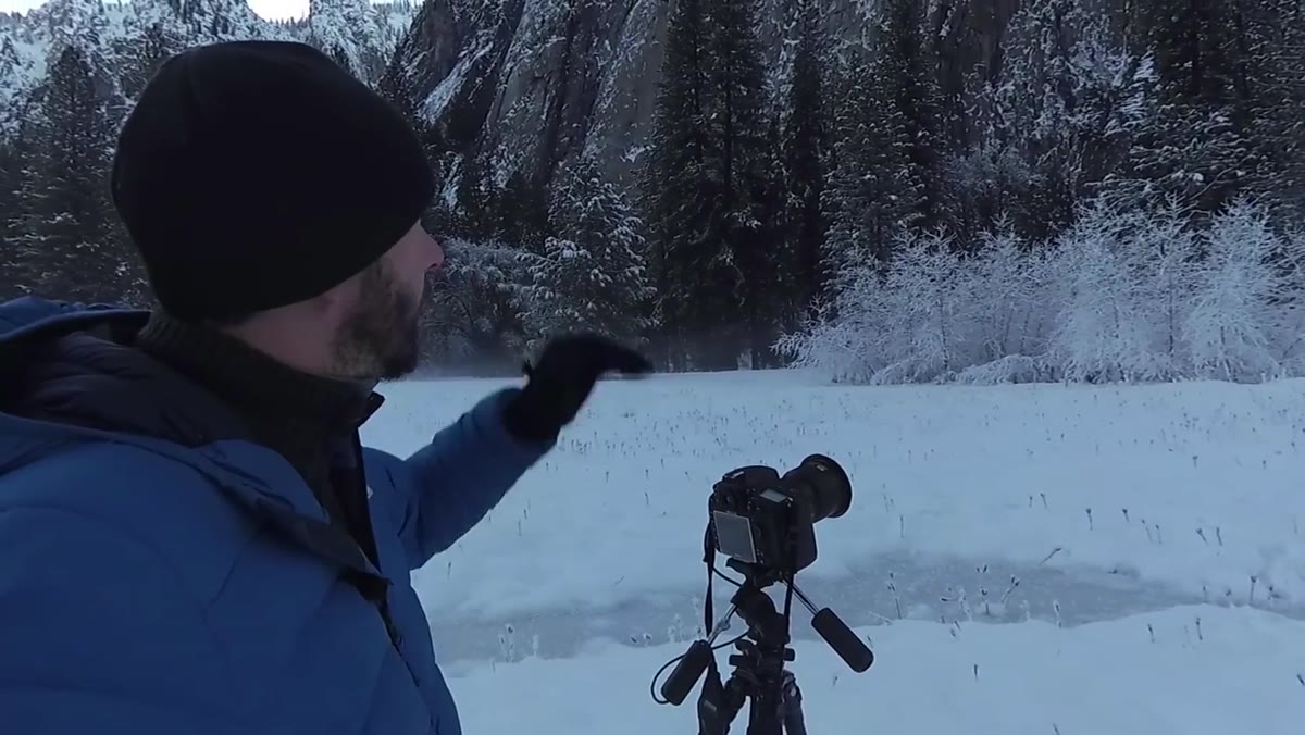 Camera settings being described at the base of the snow-covered trees