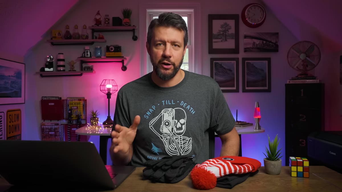 Mark holds up a warm winter hat, explaining head coverage basics