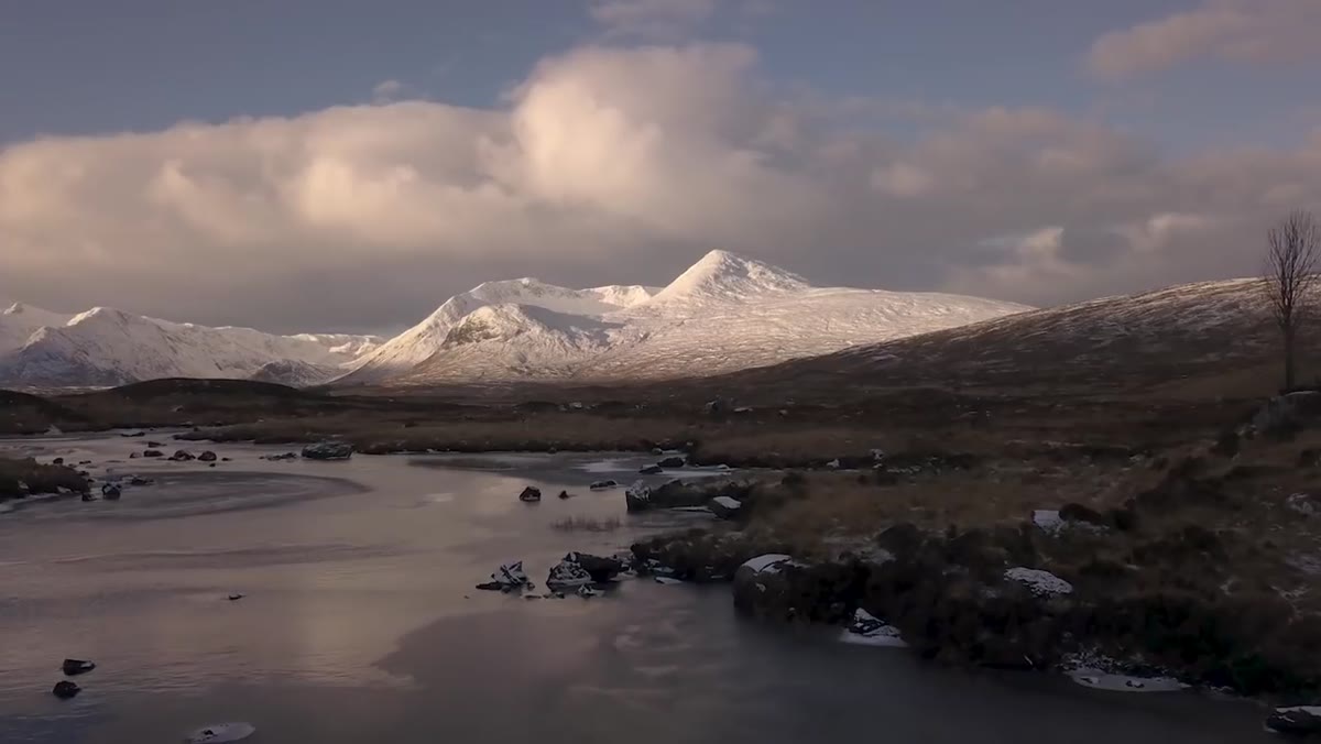 Mountain reflecting in break of ice on frozen lake surface