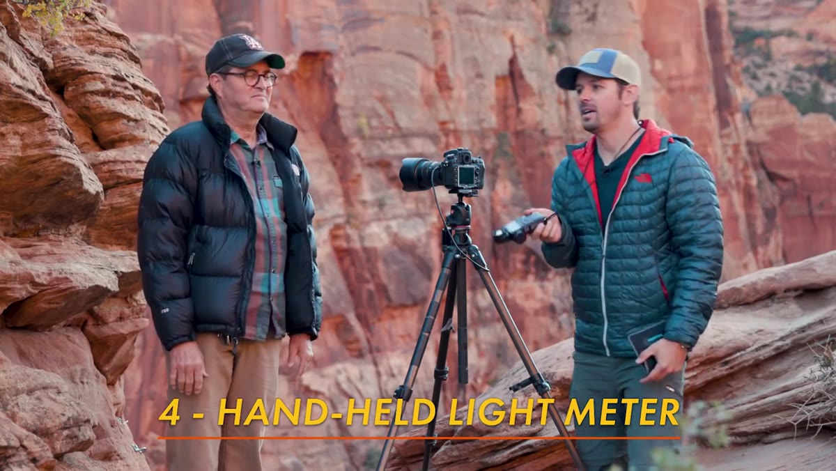 Shane using a handheld incident light meter on location