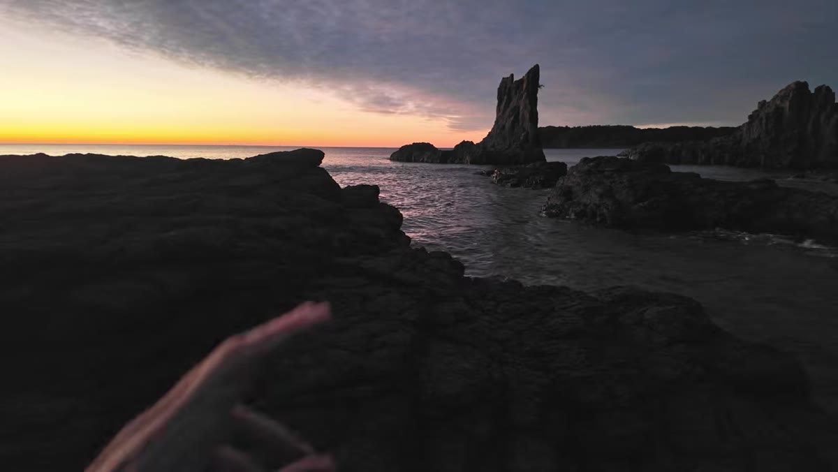Wide composition framing foreground rock and distant stack