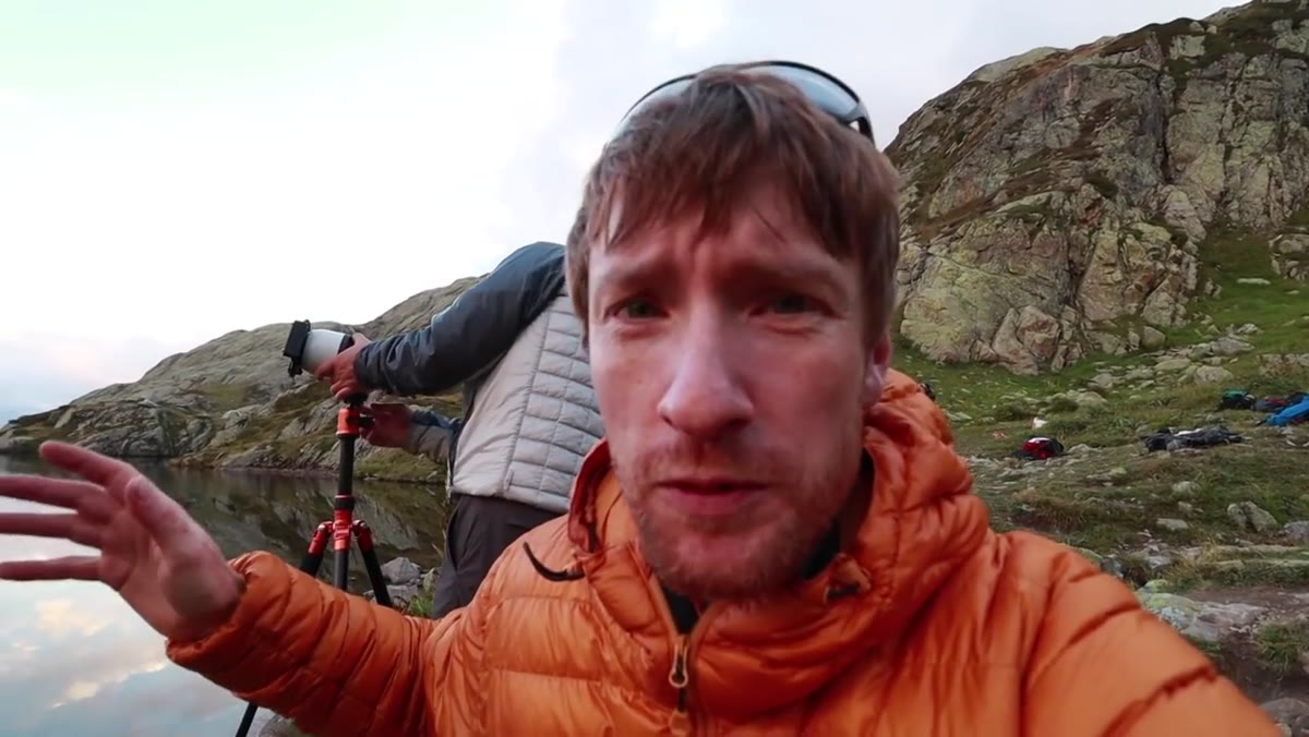 Heaton pointing to mountain peaks emerging through cloud gaps