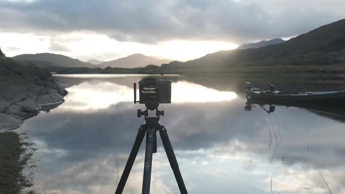 Thomas low to the ground shooting grasses in lake foreground