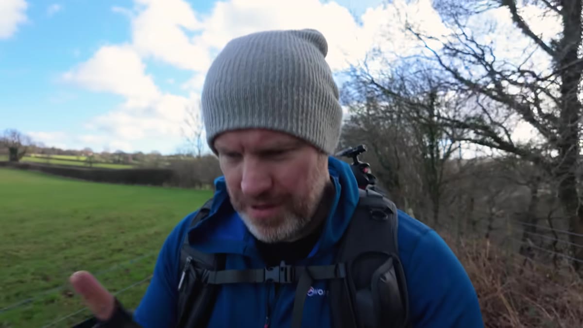 Waterfall visible in background as photographer continues walking