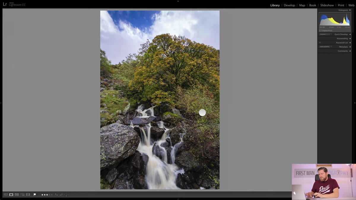Camera positioned over roadside wall to capture waterfall