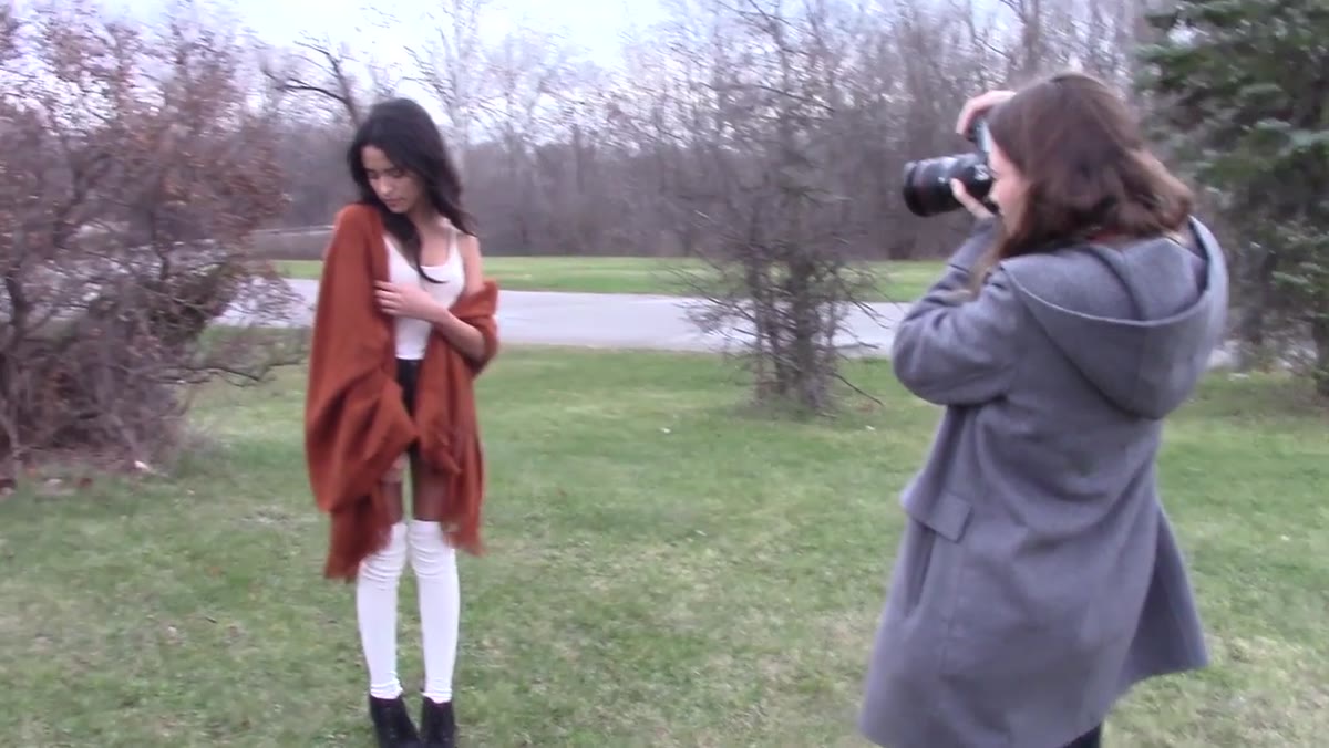 Subject adjusting sweater while photographer gives direction