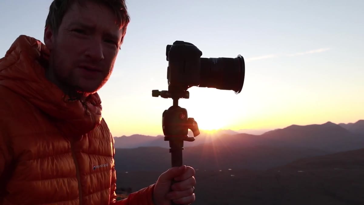 Photographer running across hillside to new position as sun rises