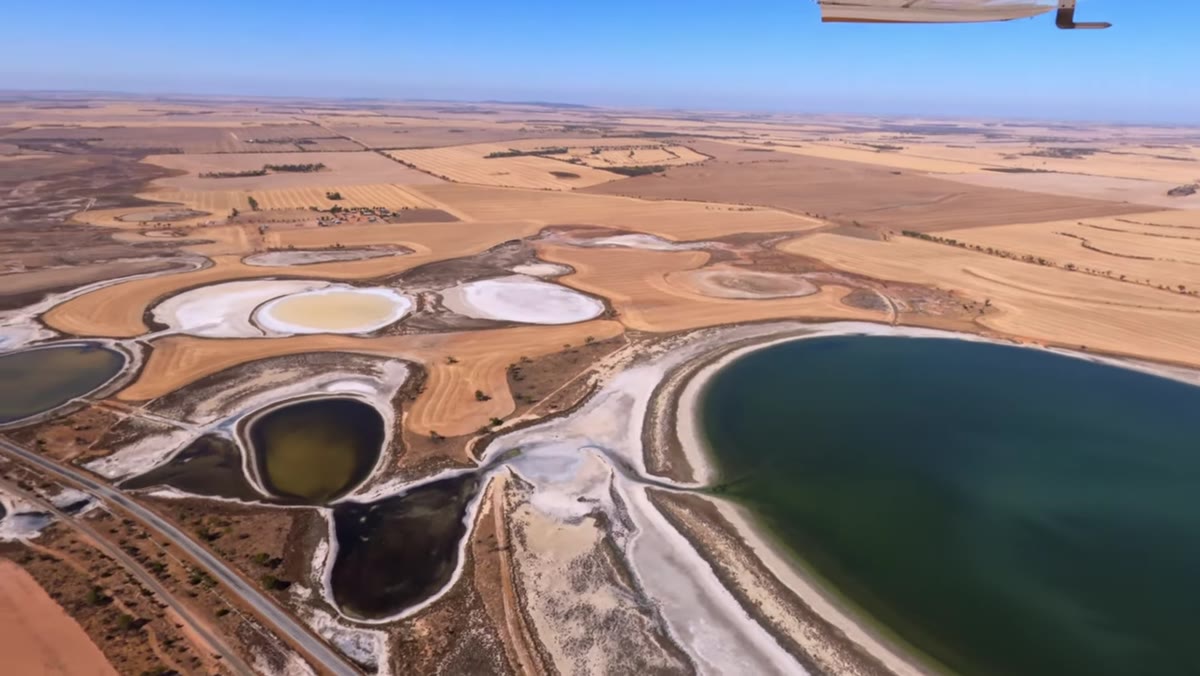 Salt lake with white evaporated areas and pink-blue water layer