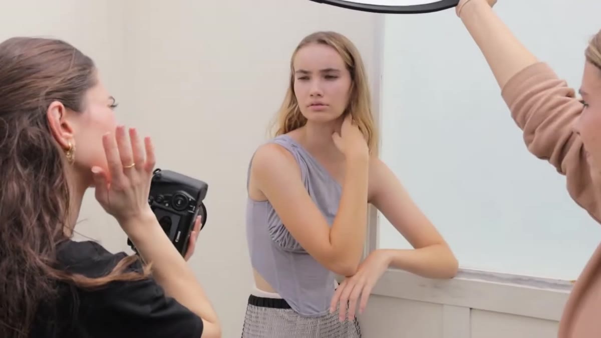 Photographer giving specific hand and arm placement directions to model