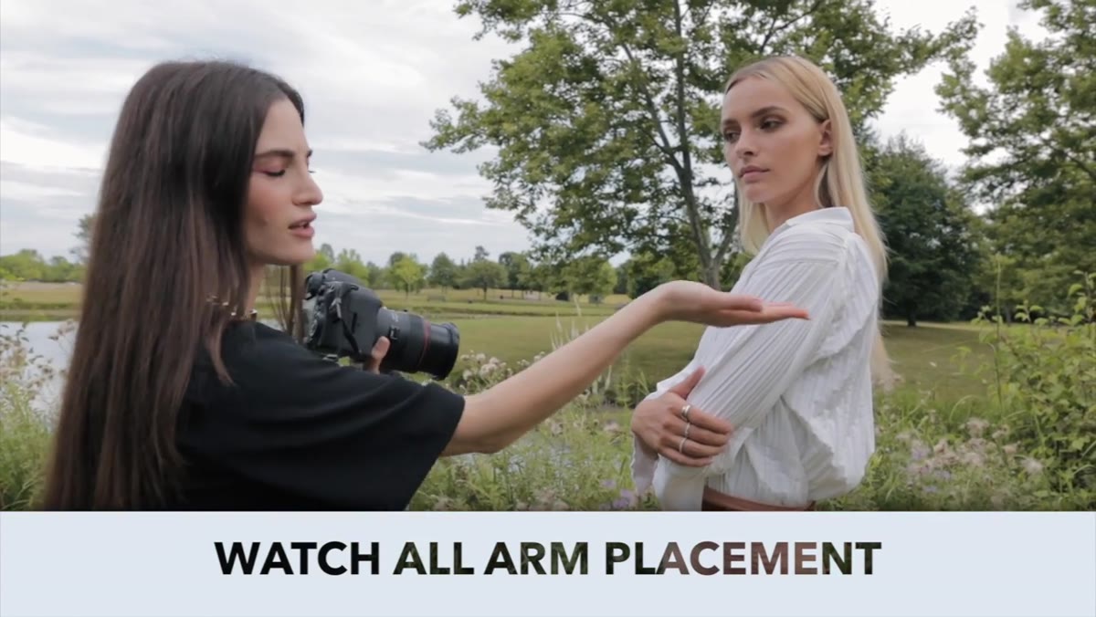 Photographer adjusting subject&rsquo;s arm position while standing