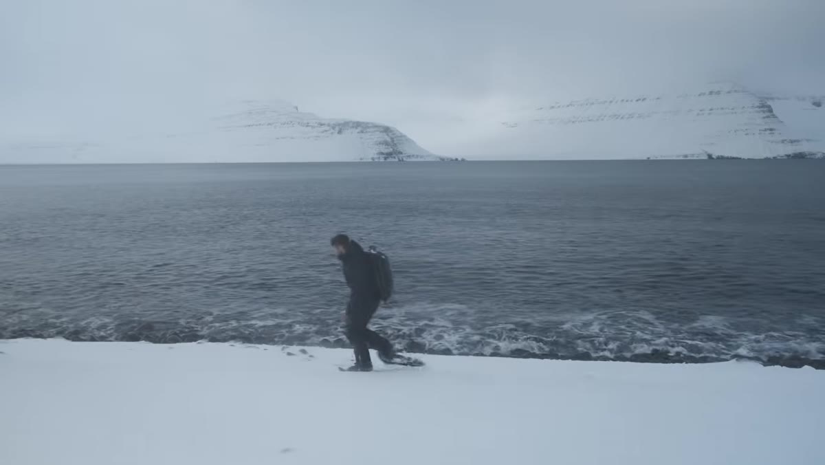 Thomas Heaton strapping on snowshoes to head into snowy terrain