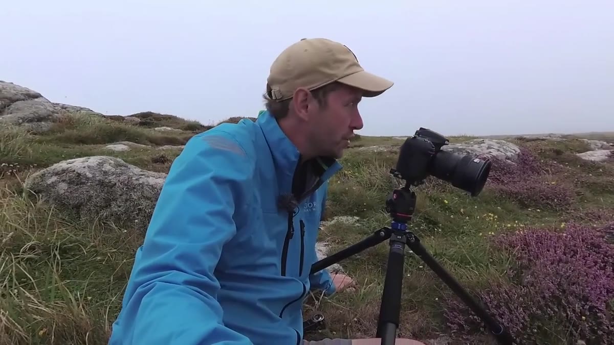 Danson crouching low with wide-angle lens over the heather