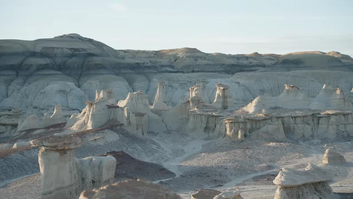 Warm sidelight raking across a row of hoodoos with shadowed background