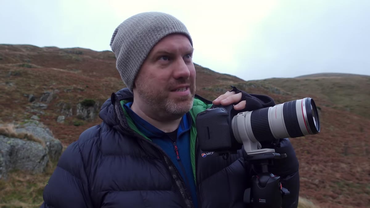 Adam switching to a longer lens and zooming in on cloud formations over ridges