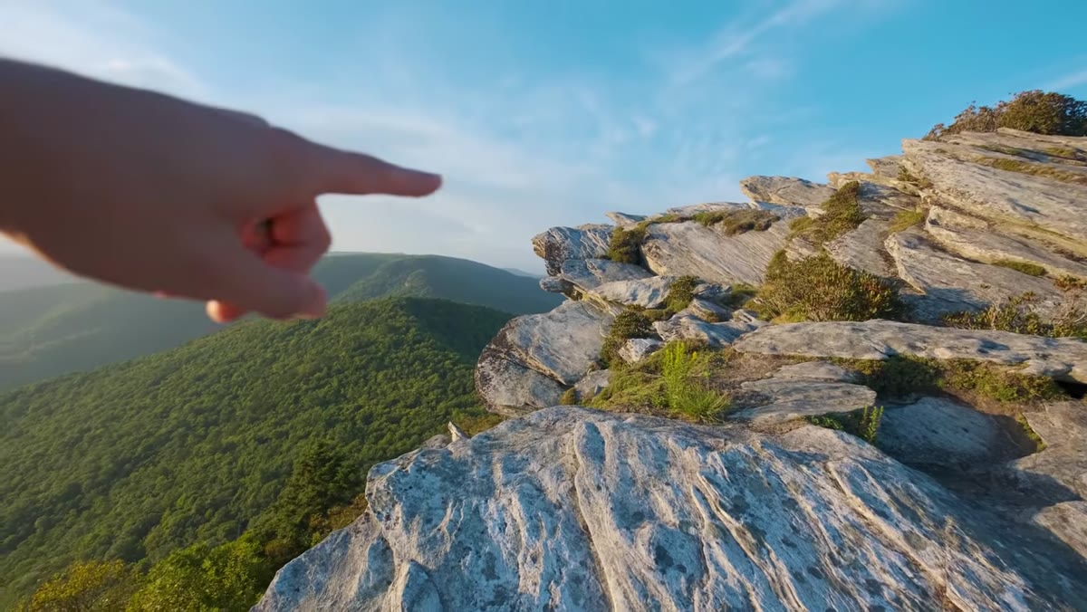 Photographer evaluating rock formations against evening light direction