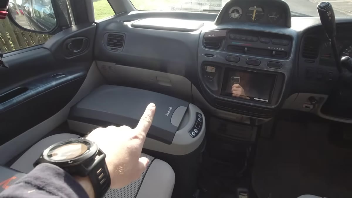 Interior of van showing fridge, Jackery power station, gear