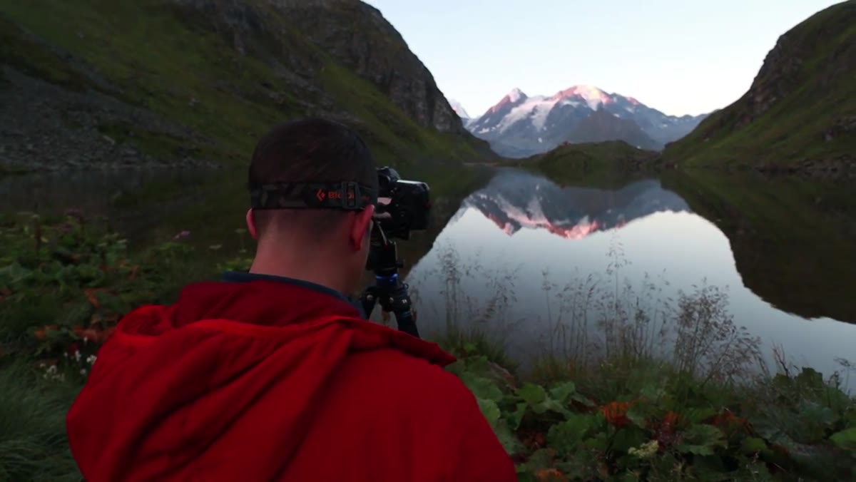 Heaton filming at lakeside at golden hour, camera already framed up