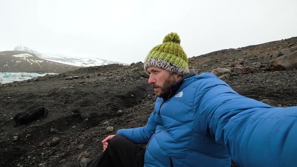 Danson and companion in falling snow, evaluating the glacier composition