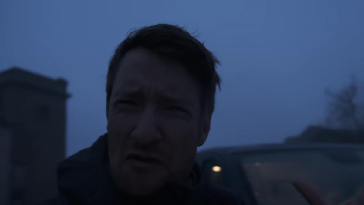 Heaton standing in rain, evaluating whether conditions are worth shooting